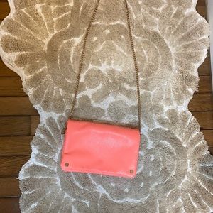 Coral crossbody/clutch with gold stud and chain detail.